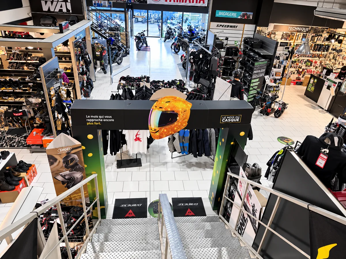 Vue en plongée depuis une mezzanine : arche Le Mois du Casque au seuil d'un corner Speedway