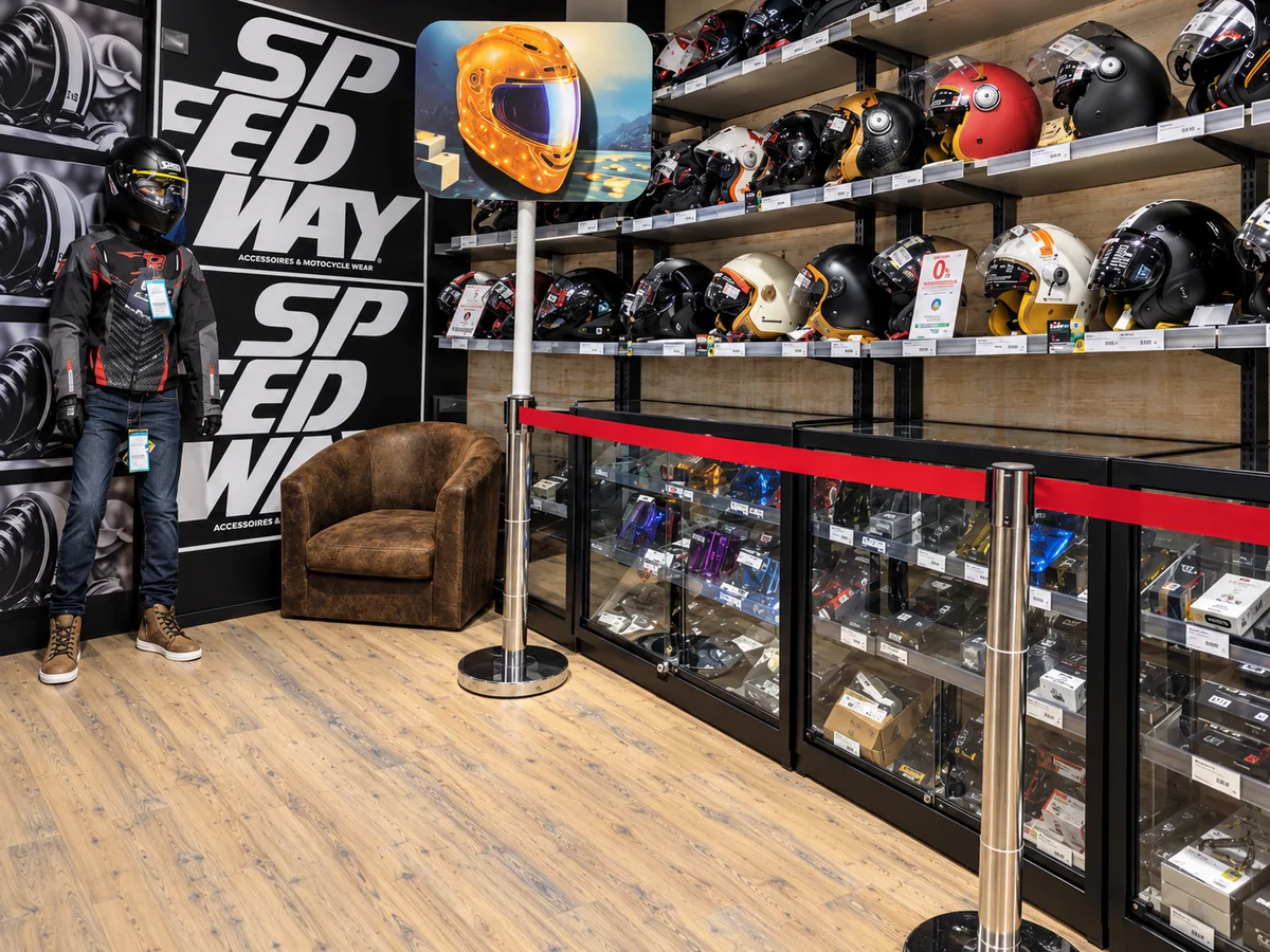 Fronton sur mât Le Mois du Casque dans un magasin Speedway, casque doré au-dessus du rayon