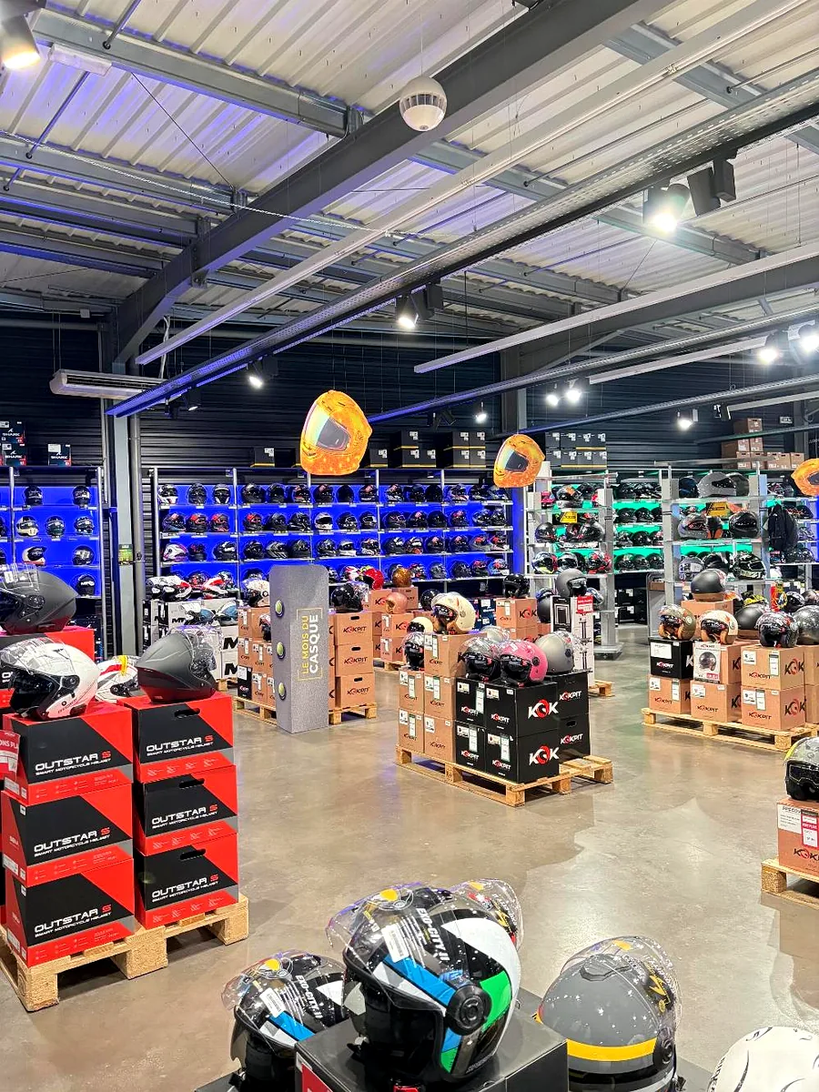 Vue large d'un magasin Speedway : PLV suspendues en forme de casque au-dessus des implantations palette