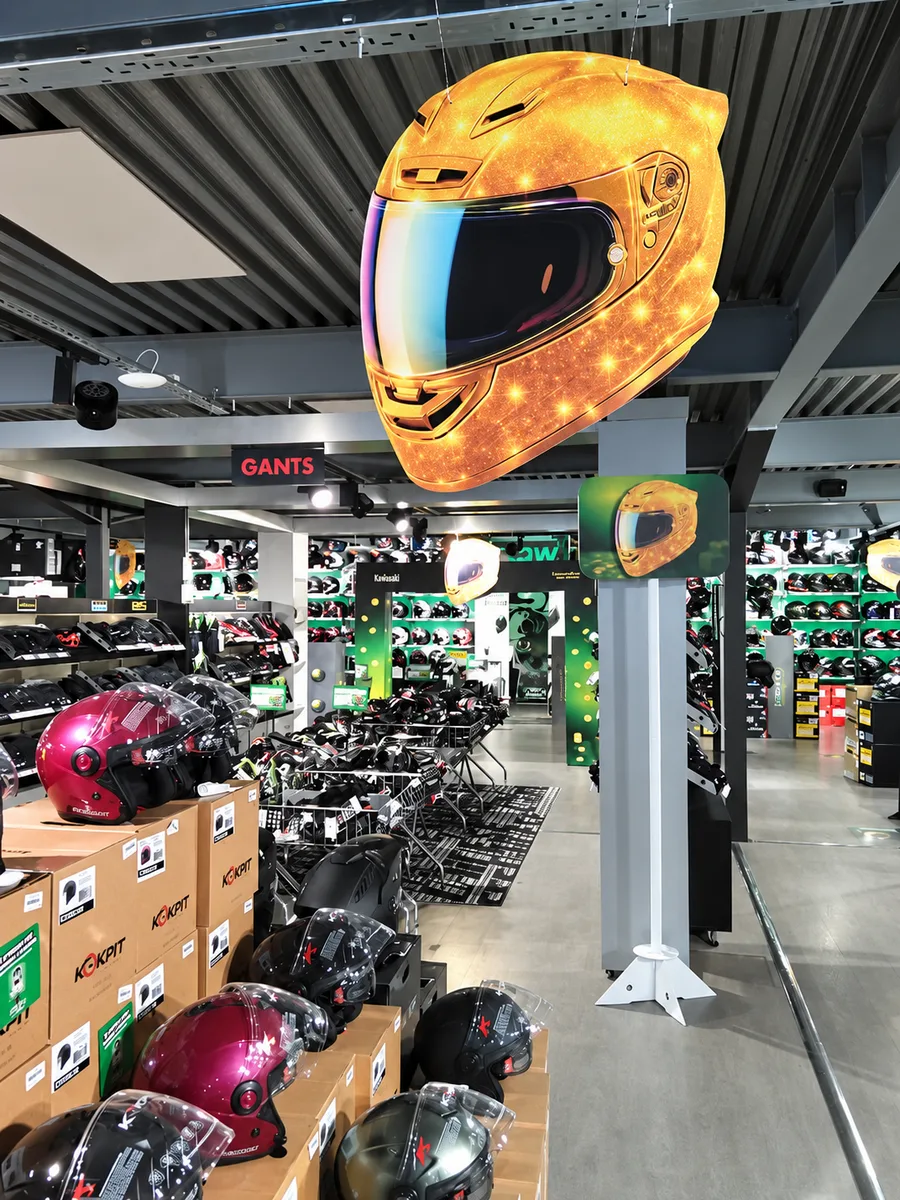 Magasin Speedway pendant l'opération : mobile casque suspendu au premier plan et fronton sur mât au fond de l'allée