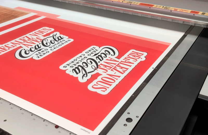 Impression numérique quadri des éléments du stand de dégustation Coca-Cola sur la table à plat de l'atelier Kontfeel