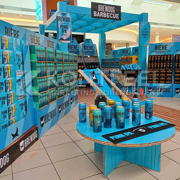 PLV carton personnalisée pour animation commerciale avec table basse reboard, sticker de sol et mobilier événementiel